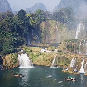 Tourist boats beneath Detian Falls, China and Vietnam transnational waterfall