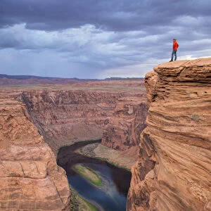 Man looking over the Horseshoe Bend and the Colorado River, Glen Canyon National Rec