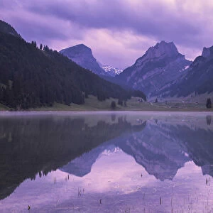 Mountains are reflected in the Samtisersee at sunrise, Canton of Appenzell, Alpstein