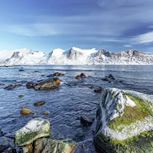 Snowcapped mountains along the cold sea in winter, Mefjordvaer, Senja, Troms county, Norway