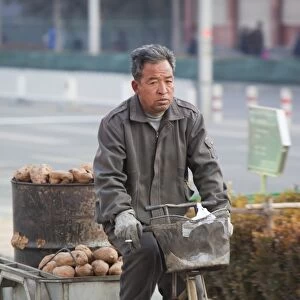 A peasant farmer cycles hius produce to a market in Beijing, China