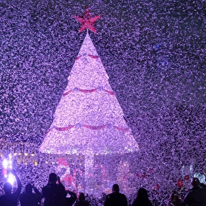 People gather under a Christmas Tree, marking the beginning of Christmas season in