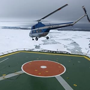 Helicopter taking off with tourists from heli-deck of ice-breaker on route to Snow