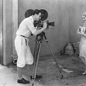 MOVIE CAMERA, 1920s. An actress poses during the filming of a motion picture, 1920s