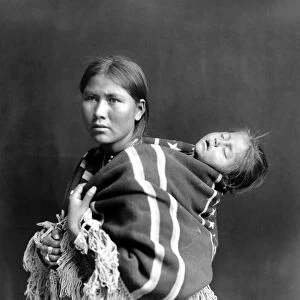 NAVAJO WOMAN & CHILD, c1914. A Navajo woman carrying a sleeping child on her back. Photograph, c1914