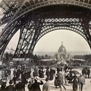 PARIS EXPOSITION, 1889. Crowds walking under the base of the Eiffel Tower while attending the Universal Expostion in Paris, 1889, looking toward the Central Dome