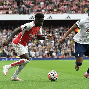 Arsenal's Bukayo Saka Clashes with Tottenham's Destiny Udogie in the 2023-24 Premier League Showdown at Emirates Stadium