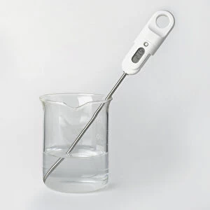 Digital thermometer in beaker of water, close-up