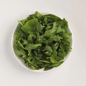 Green salad leaves in bowl, close-up