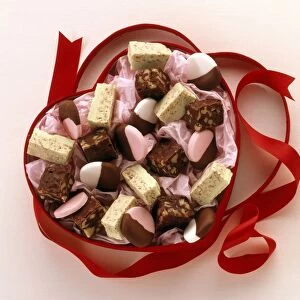 A heart-shaped box containing a selection of sweets