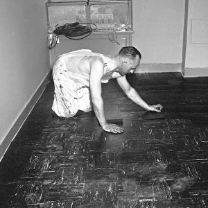 Man laying tiles on floor, (B&W)