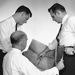 Three men looking at blueprint