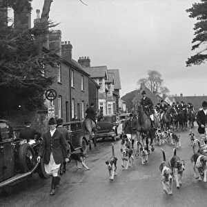 Hunting scenes in Bletchingley, Surrey. The hounds run through the streets ahead