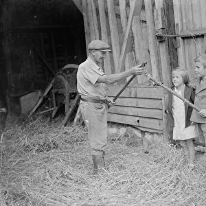 Jimmy Burrows showing flail to children. 1935
