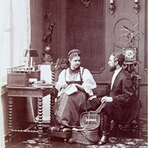 Composition a la russe : interieur d un logement russe avec homme et femme brodant et habillee en costume traditionnel. Photographie de Andrei Osipovich Karelin (1837-1906), annees 1870-1880