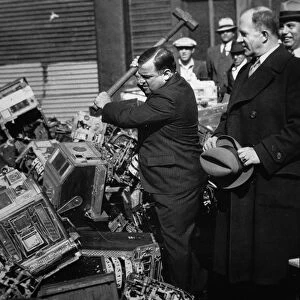 Fiorello La Guardia (1882-1947) smashing confiscated slot machines, 1934 (b / w photo)