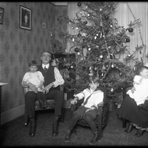Informal group portrait of unidentified family in their apartment seated in front of a