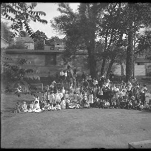 Large group of children assembled for a group portrait in an unidentified playground, c