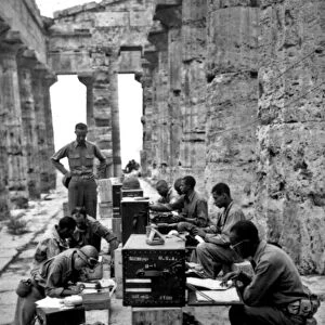 A makeshift office set up between the columns of the Greek temple of Neptune, Italy, 22nd September, 1943 (b / w photo)