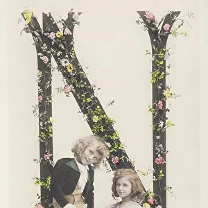 N: Capital letter decorated with flowers, a boy with a puppet and a girl with a doll. 1907 (photograph)