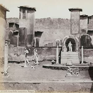 Partial view of the elevated garden of the House of Marcus Lucretius in Pompeii, decorated with marble statues and herms. At the center a fountain with a niche. In the background fragments of wall paintings