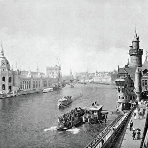 View of the 1900 Universal Exhibition taken from the Pont de l'Alma sur la Seine. On the left, the palace of hygiene and armees. On the right: the gate of Saint Michael and the tower of the Giralda
