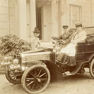 Woman and chauffeur in fine early automobile (b / w photo)