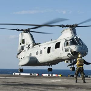 An aviation boatswains mate directs a CH-46E Sea Knight