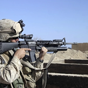 U. S. Marine sites through the scope atop his 5. 56mm M16A2 rifle while providing security