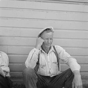 Bindle stiff, used to be logger, Side of Pastime Cafe, Tulelake, Siskiyou County, California, 1939. Creator: Dorothea Lange