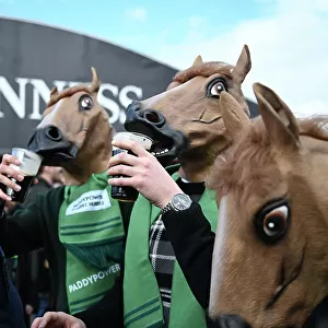 Fans get in the Cheltenham mood by sipping on their pints of Guinness while wearing a horse mask Cheltenham Festival week