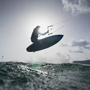 A kitesurfer on his board in mid-air; tarifa cadiz andalusia spain