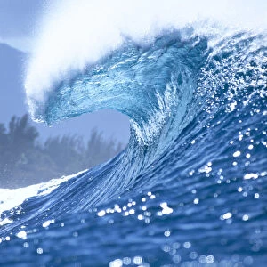 Large Shimmery Blue Wave Curling With Wind Spray, Land Visible In Background