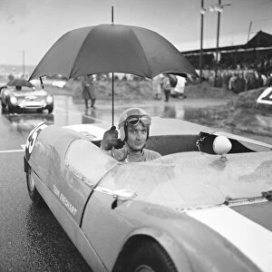 Brian Hart holds an umbrella up to keep off the heavy rain as he waits for the start of