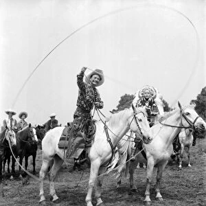 Cal McAndrew on horseback with a lasso seen alongisde - Carol Gray dressed as a Indian