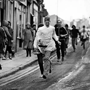 Competitors take part in the Alnwick Shrove Tuesday Pancake race 16 February 1988