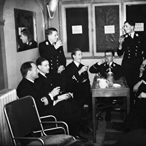 Officers of HMS Ajax and Exeter enjoying a drink during the interval at the London