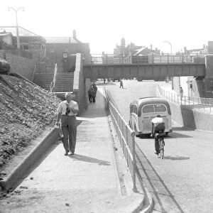 Pedestrians walking under a viaduct in Stourbridge. 1958