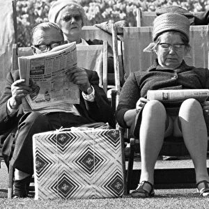Pensioners reading the newspaper whilst enjoying the afternoon sun in Embankment Gardens