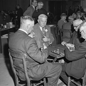 Players playing their dominoes close to their chests, at the "Over Sixties "