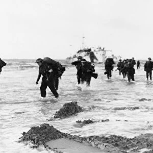 Red Cross personnel wade ashore from landing craft on Queen sector