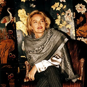 Sharon Stone actress Sitting on a chair, legs crossed, wearing a scarf