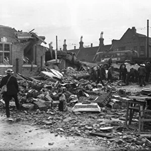 Workmen clear away the rubble following an air raid on Putney, London