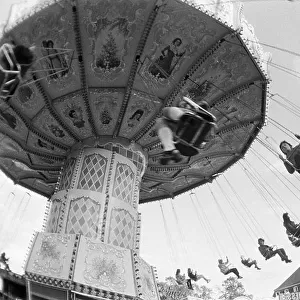 Seventies, black and white photo, kermess, people on a chairoplane