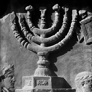 Detail of the bas-reliefs of the Arch of Titus, Rome, depicting the candelabrum with seven arms, carried on the shoulders by two men with a laurel wreath