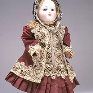 Bisque baby doll with crying mechanism, made in France in the second half of the Nineteenth century. The elegant dress, with its bonnet, has lots of lace decoration