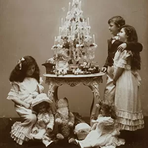 Children near a small table with a little Christmas tree and some toys