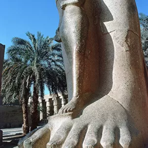Luxor. Karnak. The colossal statue of Ramses II at the foot of the queen. Despite catuche of Pharaoh carved on the base of the statue the King Priest, who reigned over Thebes Pinedjem The two centuries later, usurped the identity of the statue and comes t