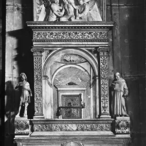 Marble tabernacle with the reliquary of the blood of Christ, and the bas-relief of St. Mary Magdalene on the bronze door of the ciborium. St. Francis and St. John the Baptist by Tullio Lombardo are on the sides; Christ supported by two angels is above it. Church of Santa Maria Gloriosa dei Frari, Venice