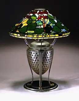 A Geranium table lamp with a conical shade, and reticulated bronze urn base